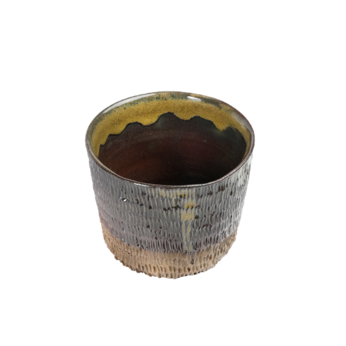 Close-up of yellow and brown glaze drips on Hedgehog Tumbler, Mocha Cat Pottery