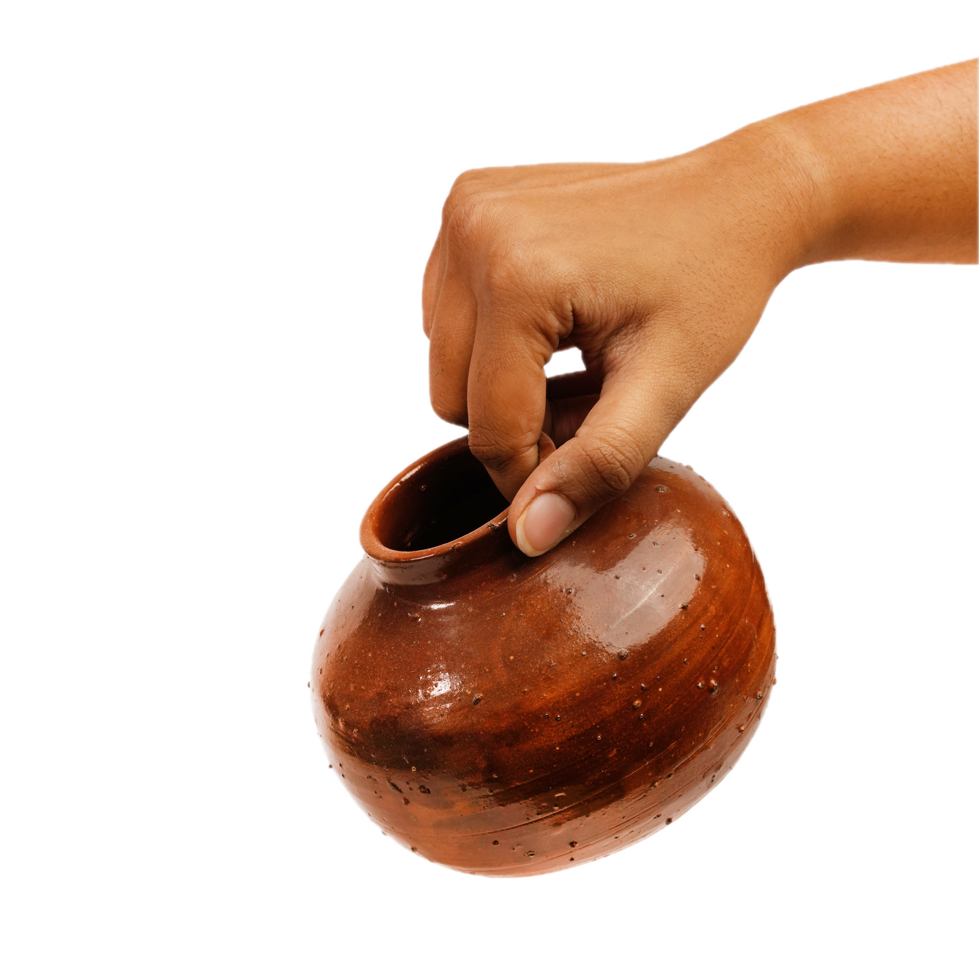 A hand holding a small, rounded brown ceramic pot with a glossy finish against a solid white background.